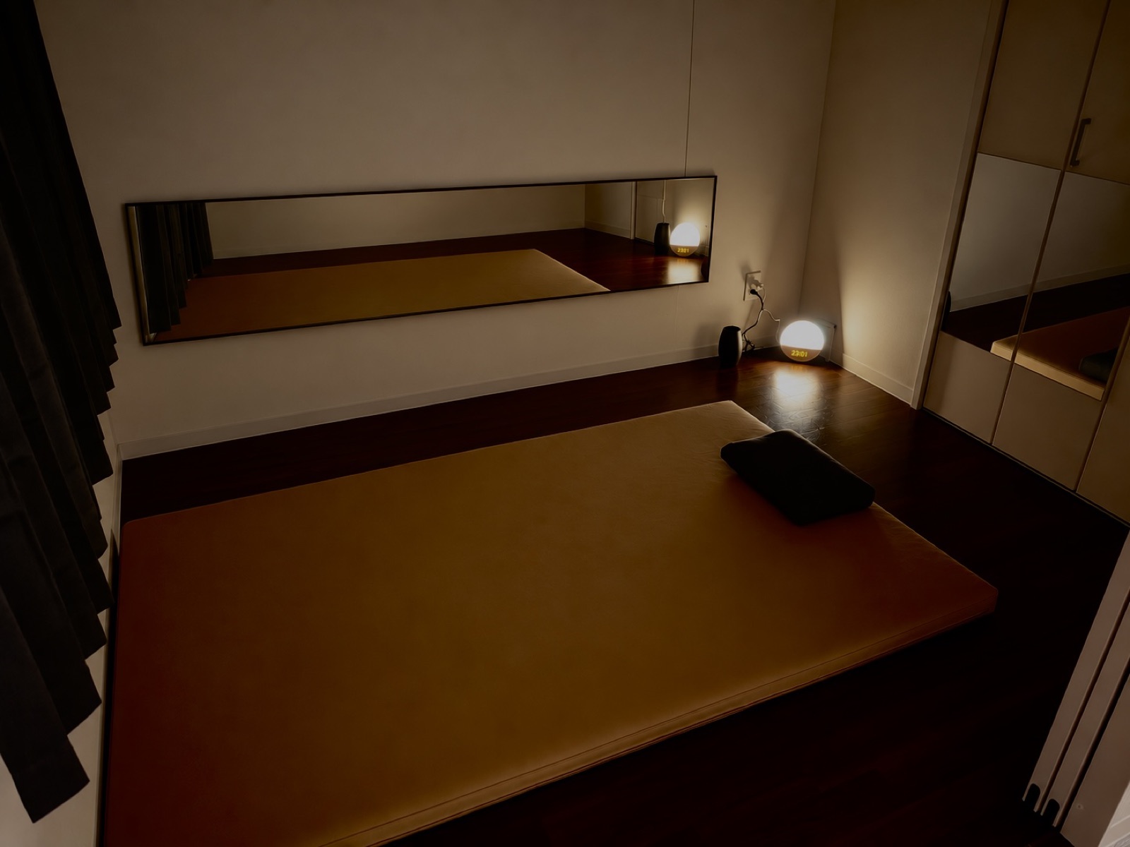 EMの施術ルーム。照明を落とした完全個室に、専用マットとミラーがある